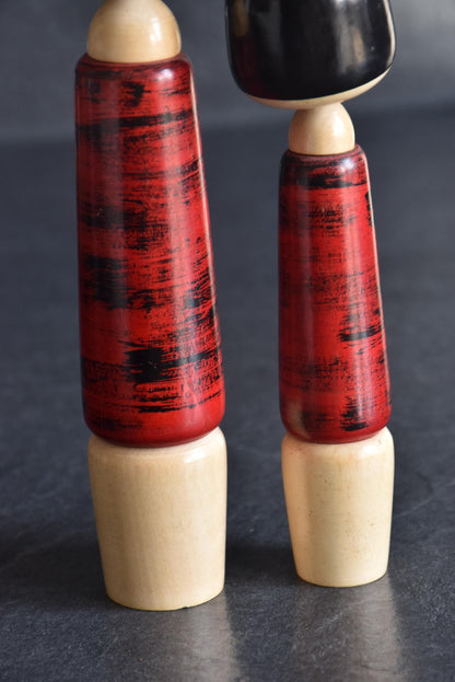 Aida Seihou kokeshi Sisters lower body detail displaying the textured red bark finish and wooden bases