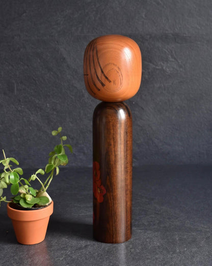 Ryozo Tsujita kokeshi doll viewed from the back, showing the natural wood grain on the head