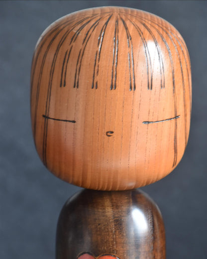 Ryozo Tsujita kokeshi doll head detail showing painted facial features and incised hair lines