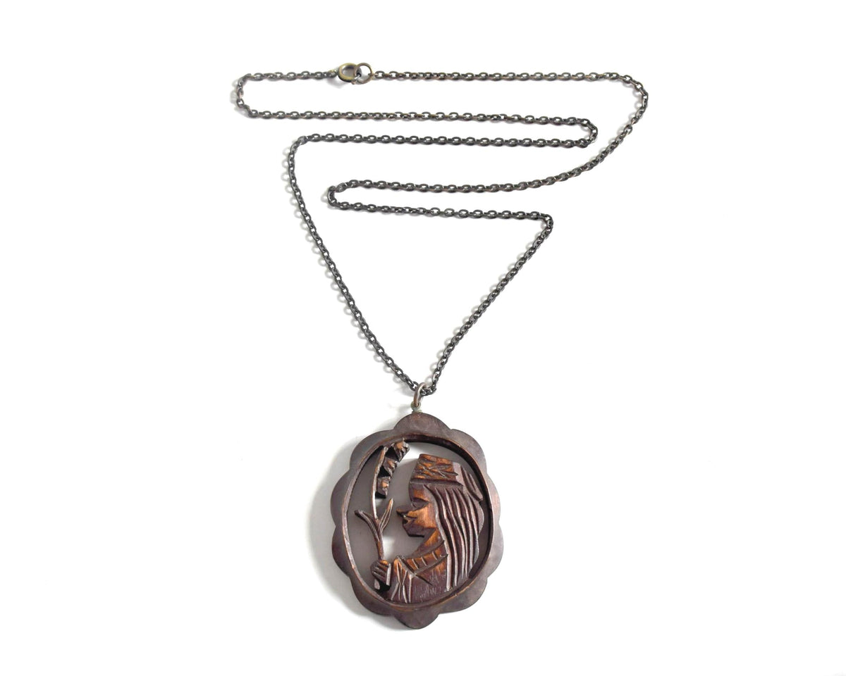 Ainu wooden pendant necklace complete with chain laid flat on white surface
