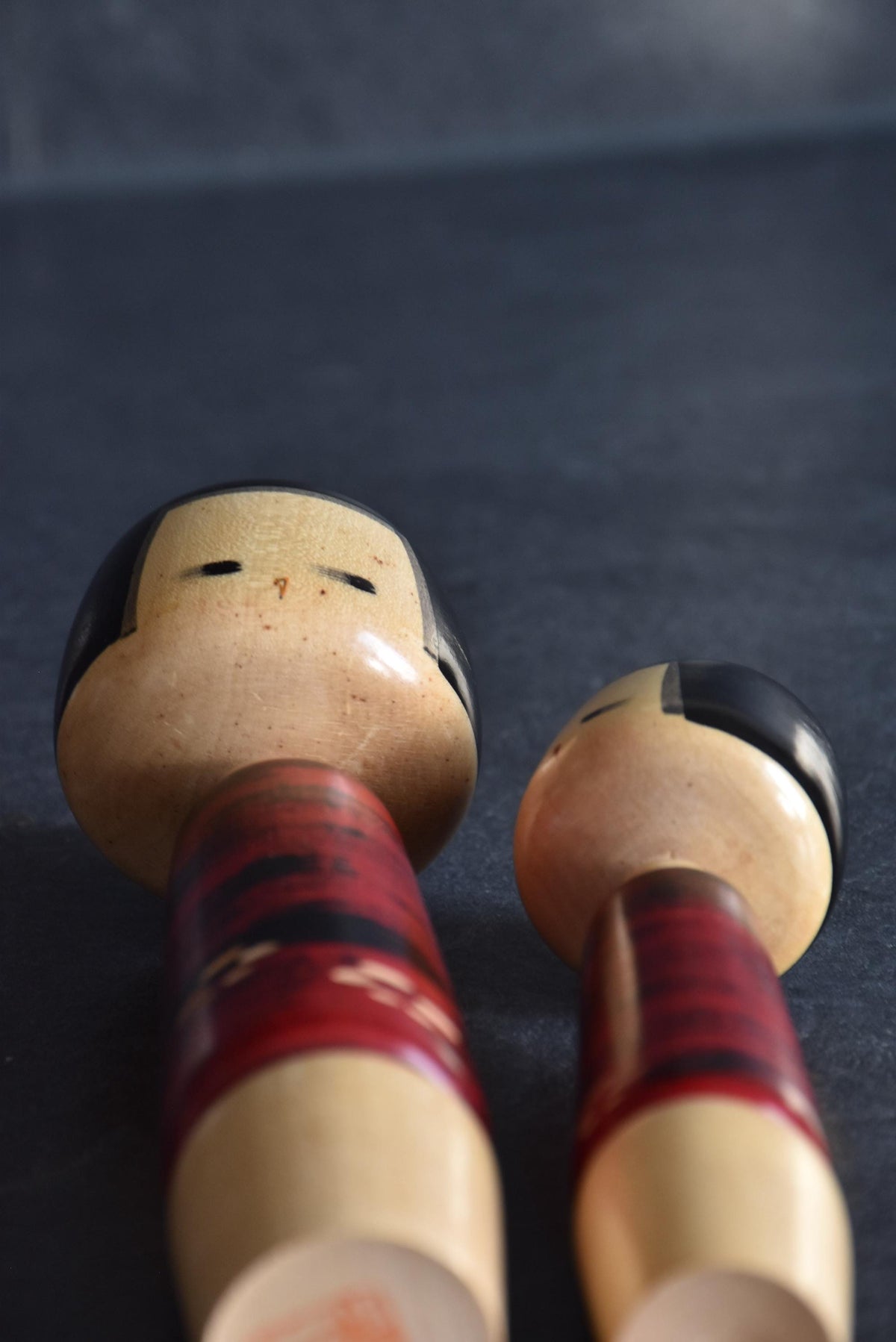 Aida Seihou kokeshi Sisters low angle view emphasizing the serene facial expressions and wood features