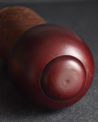 Sosaku Kokeshi Shijo by Sato Suigai showing the back of the deep burgundy sculpted hairstyle